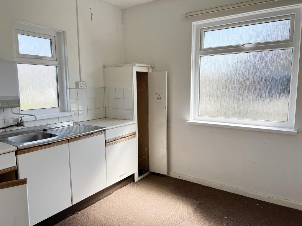 Lot: 51 - FORMER CHURCH WITH PLANNING PERMISSION FOR CONVERSION AND VACANT HALL - Kitchen area of community hall with white fitted kitchen cupboards
